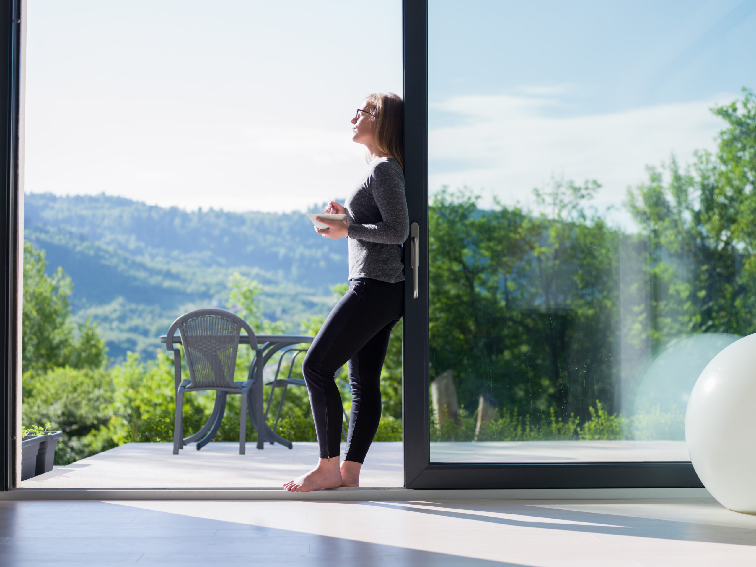woman eating breakfast in front of her luxury home villa